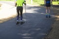 A man rides a ski roller on an asphalt road in the Park in the summer Royalty Free Stock Photo