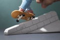 A man rides a small fingerboard on a plaster ramp Royalty Free Stock Photo
