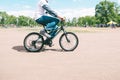 Man rides a small mountain bike on a summer sunny day. Walk around the park on a bike. Adult man on a children`s bike Royalty Free Stock Photo