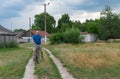 Man riding on an ancient bicycle on a country road Royalty Free Stock Photo