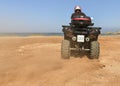 A man riding ATV in sand in a helmet. Royalty Free Stock Photo