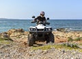 A man riding ATV in sand in a helmet. Royalty Free Stock Photo