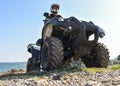 A man riding ATV in sand in a helmet. Royalty Free Stock Photo