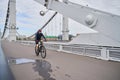Man riding on bicycle across the bridge in the city. Royalty Free Stock Photo