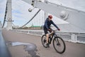 Man riding on bicycle across the bridge in the city. Royalty Free Stock Photo