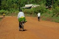 Man riding a bicycle with a bunch of bananas in Africa