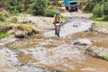 Man riding bicycle, crossing the river in the highlands of Guatemala.