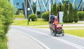 A man riding a bicycle with a little boy wearing a helmet inside a child seat, on a bike path Royalty Free Stock Photo