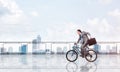 Man riding bicycle on penthouse balcony Royalty Free Stock Photo