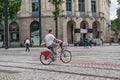 Man riding with a bicycle rental with a package in the hands