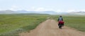 Man Riding Bike through Mongolian Steppes