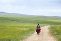 Man Riding Bike through Mongolian Steppes
