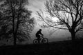 Man riding a bike uphill through foggy autumn morning Royalty Free Stock Photo