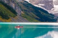 Man riding a Canoe on iconic turquoise Lake Louise in the Canadian Rockies