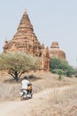 Man riding electric scooter towards temples and pagodas of ancient Bagan in Myanmar