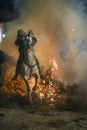 A man riding his horse jumping throug the fire