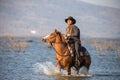 Cowboy on his horse walking through dust in the lake Royalty Free Stock Photo