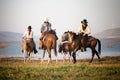 Man riding horse in lake against sunset and mountain Royalty Free Stock Photo