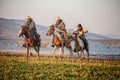 Man riding horse in lake against sunset and mountain Royalty Free Stock Photo