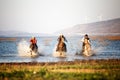 Man riding horse in lake against sunset and mountain Royalty Free Stock Photo