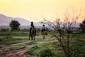 Man riding horse in lake against sunset and mountain Royalty Free Stock Photo