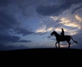 Man riding horse over sunset