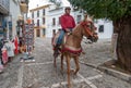 Man riding horse on street of Ronda, Spain