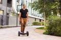 Man riding hoverboard, city. Guy on blue gyroboard Royalty Free Stock Photo