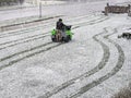 Man Riding a Fertilizer Spreader In Snow