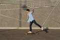 Young man riding longboard in urban street skatepark. Casual hipster guy wear bandana skateboarding Royalty Free Stock Photo