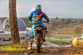 Man riding a motocross in a protective suit in the mud Royalty Free Stock Photo