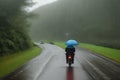 Man riding a motorcycle in bad rainy weather