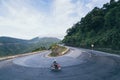 Man riding motorcycle on winding roads of Hai Van pass from Hue city to Hoi An, Vietnam