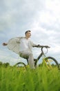 The man is riding a mountain bike. A fashionable guy came to nature in the field. The guy on the background of nebt. Bright yellow Royalty Free Stock Photo
