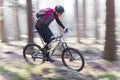 Man riding a mountain bike in a forest on a sunny day with fog Royalty Free Stock Photo