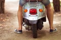 Man riding old retro scooter in a city street. Close up Royalty Free Stock Photo