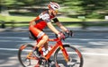 Man riding orange racing bike on road blurred background