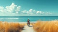 Man riding scooter through tall grass towards the ocean Royalty Free Stock Photo