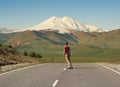 Man Riding on skateboard on Road to Elbrus