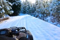 Man riding snowmobile or fourwheeler on the country side trail near water canal