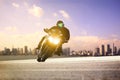 Man riding sport motorcycle lean on curve road against urban skyline background