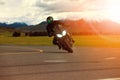 man riding sport motorcycle leaning in sharp curve with traveling scene background Royalty Free Stock Photo