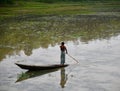 Man riding on a wooden boat around a lake