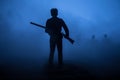 Man with riffle against zombie attack. Zombie apocalypse. Scary view of blurred zombies at cemetery and spooky cloudy sky with fog Royalty Free Stock Photo