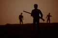 Man with riffle against zombie attack. Zombie apocalypse. Scary view of blurred zombies at cemetery and spooky cloudy sky with fog Royalty Free Stock Photo