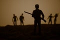 Man with riffle against zombie attack. Zombie apocalypse. Scary view of blurred zombies at cemetery and spooky cloudy sky with fog Royalty Free Stock Photo