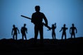 Man with riffle against zombie attack. Zombie apocalypse. Scary view of blurred zombies at cemetery and spooky cloudy sky with fog