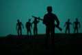 Man with riffle against zombie attack. Zombie apocalypse. Scary view of blurred zombies at cemetery and spooky cloudy sky with fog Royalty Free Stock Photo