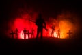 Silhouettes crowd of hungry zombies and old windmill on hill against dark foggy toned sky. Silhouettes of scary zombies walking at