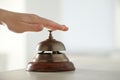 Man ringing hotel service bell at table indoors. Space for text Royalty Free Stock Photo